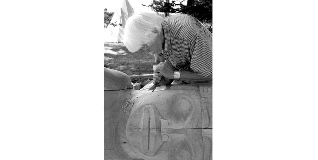black and white photo of Bill holm carving at Camp Nor'Wester by Greg Blomberg.