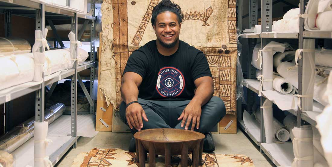 A young man sits with a kava bowl in front of him