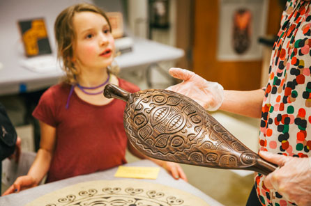 a young girl talks to a burke staff member about a oceanic paddle she's holding