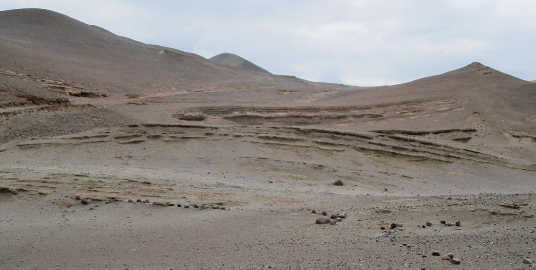 A view of a sandy desert with grey sky