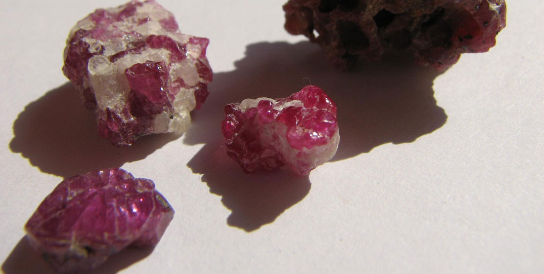 Four small rough rubies on a table