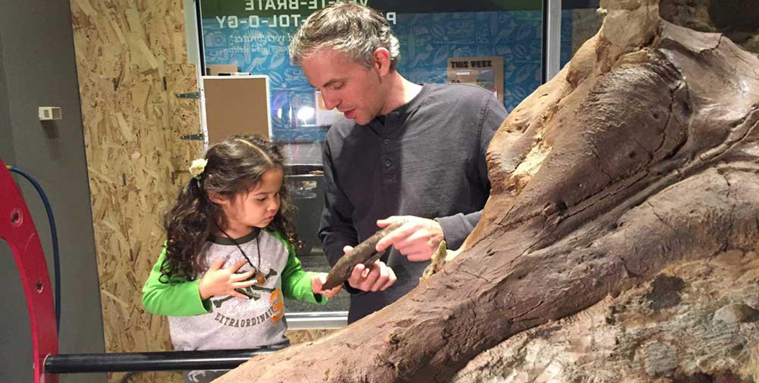 A t.rex preparator shows a young girl a 3-D printed tooth