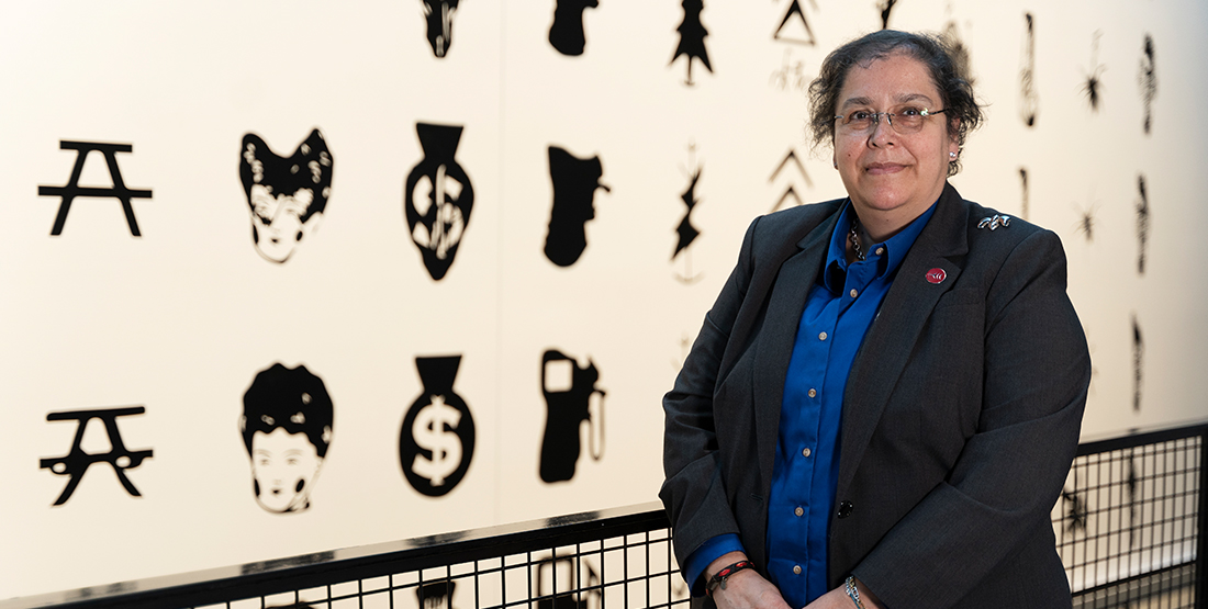 a woman stands in front of a wall with black and white icons on it