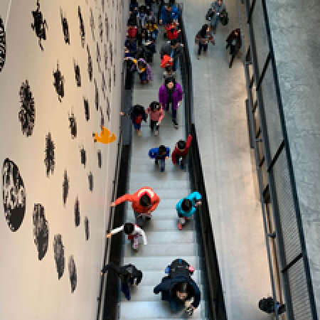 a group of school children run up the stairs to the new burke