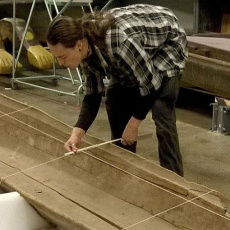A man lays string to create offset lines for the 3D scan of the canoe