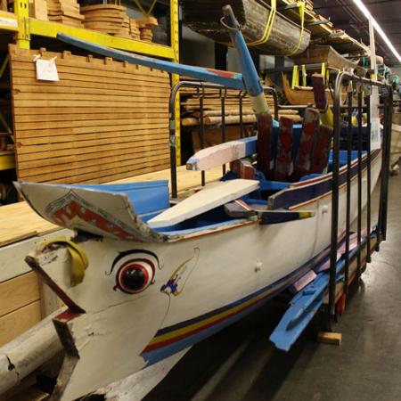 A boat decorated with blue, white and yellow and a painted eye