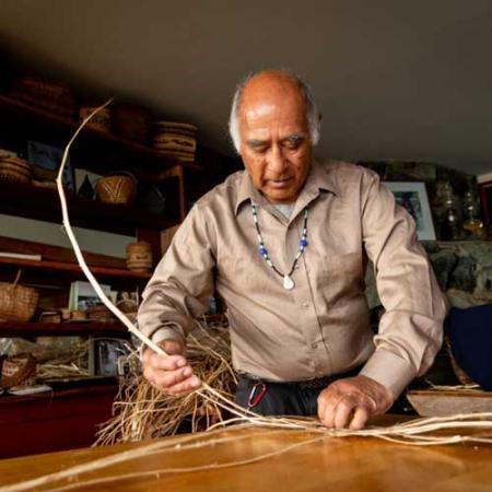 Carriere starts a basic weave with the split cedar limbs. Photo by Stuart Isett