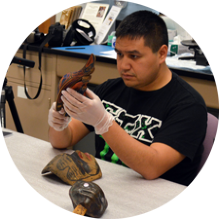 a man looks closely at an object in the collection