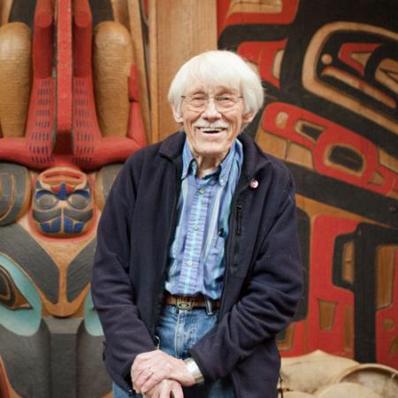 a man stands in front of his workshop at his house