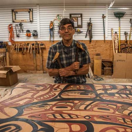 david boxley poses in his shop surrounded by carving tools