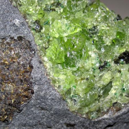 A chunk of green peridot within a larger chunk of rock