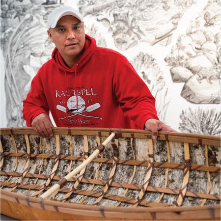Shawn Brigman stands next to the bark sturgeon-nose canoe he made over the last year through the Bill Holm Center Artist-In-Residence Grant.