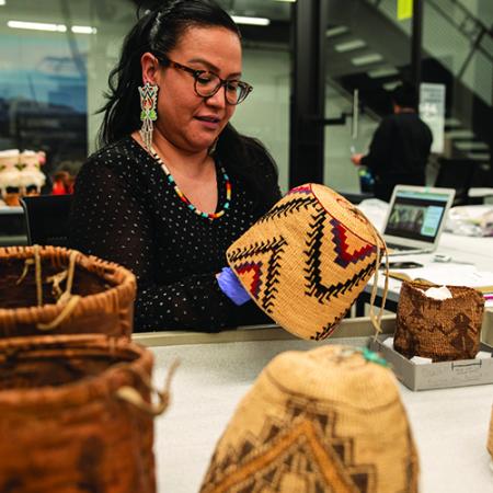 A woman holds and examines baskets