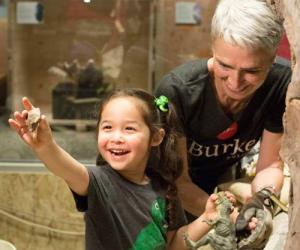 A young girl extending her arm to show her mom a piece of rock she found